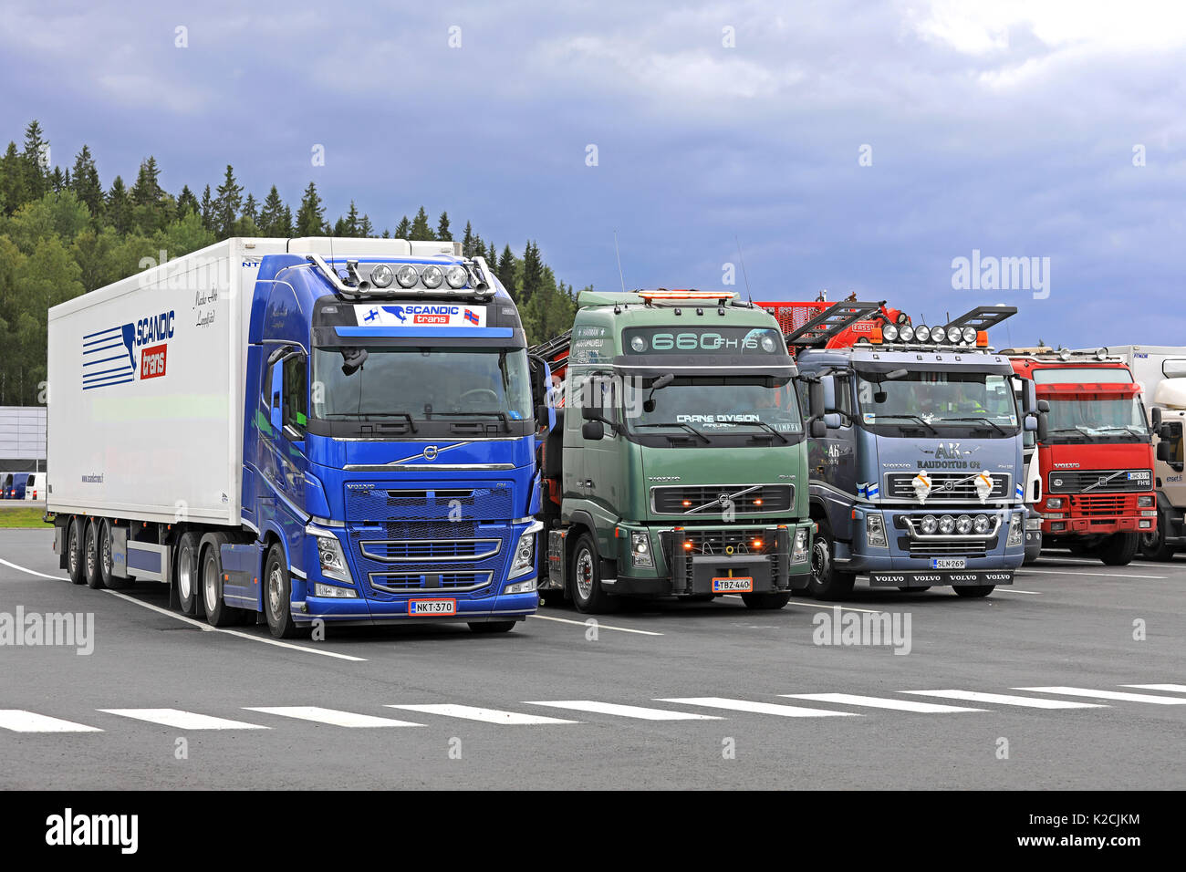 FORSSA, Finlandia - 25 agosto 2017: Colorful Volvo FH carrelli parcheggiati sul cantiere di asfalto di un arresto carrello il carrello verde lampeggia luci ausiliarie breve Foto Stock