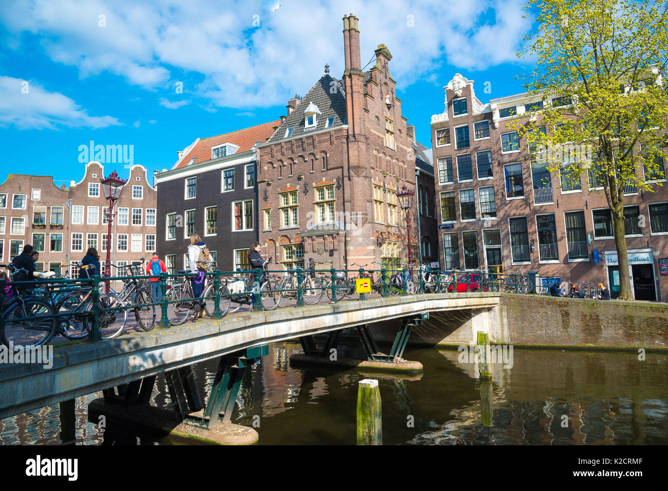 Amsterdam, Paesi Bassi - 19 aprile 2017: i turisti a piedi su un antico ponte di pietra nella parte storica di amsterdam, Paesi Bassi Foto Stock