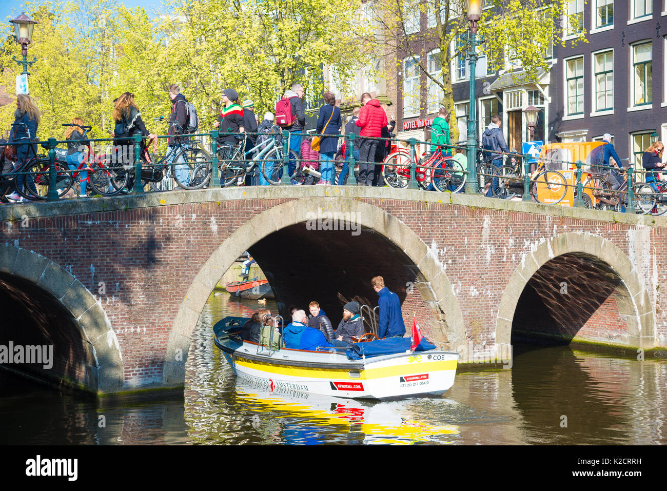 Amsterdam, Paesi Bassi - 19 aprile 2017: i turisti a piedi su un antico ponte di pietra nella parte storica di amsterdam, Paesi Bassi Foto Stock