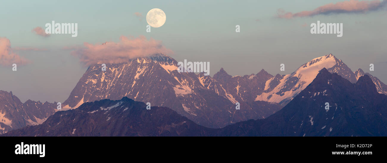 Full Moon Rising oltre l'Watzespitze (3554m), parte dell'Glockturmkamm, la cresta occidentale delle Alpi Otztal. Nordtirol, Alpi austriache. Luglio. Cucito digitalmente panorama. Foto Stock