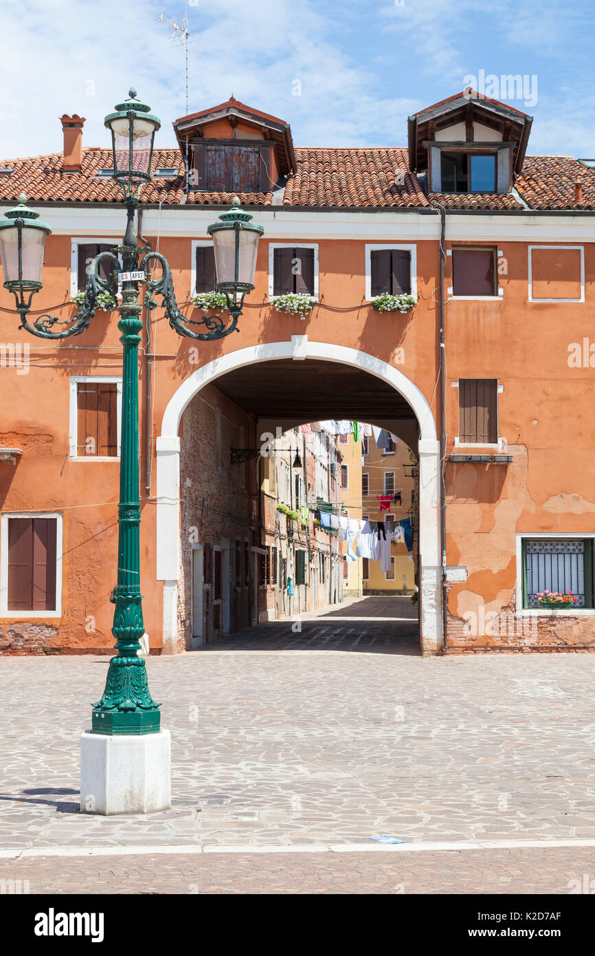 Guardando attraverso un arco in Calle Colonna, Castello, Venezia, Italia sul giorno di lavaggio dalla Riva dei Sette Martiri veneta con una lampada posta nel foreg Foto Stock