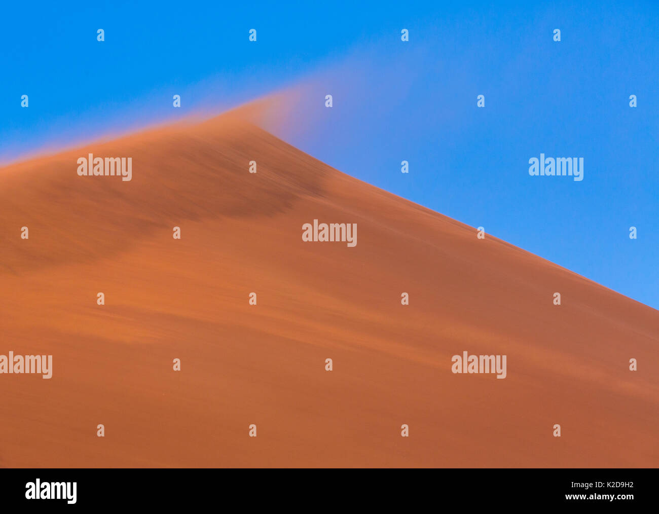 In alto di dune di sabbia con il vento che soffia sulla sabbia, Namib Naukluft National Park, Namibia Foto Stock