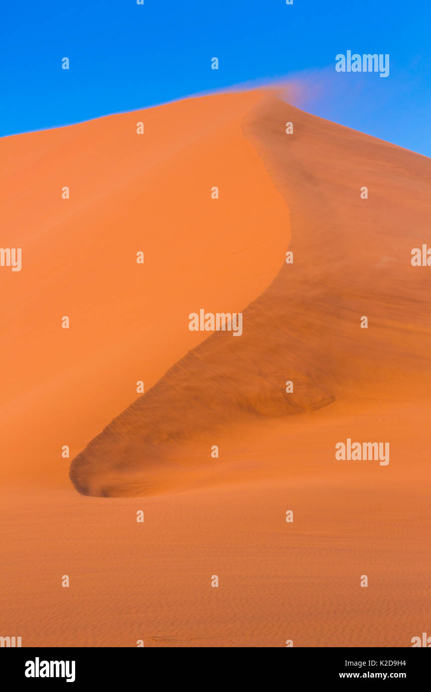 In alto di dune di sabbia con il vento che soffia sulla sabbia, Namib Naukluft National Park, Namibia Foto Stock