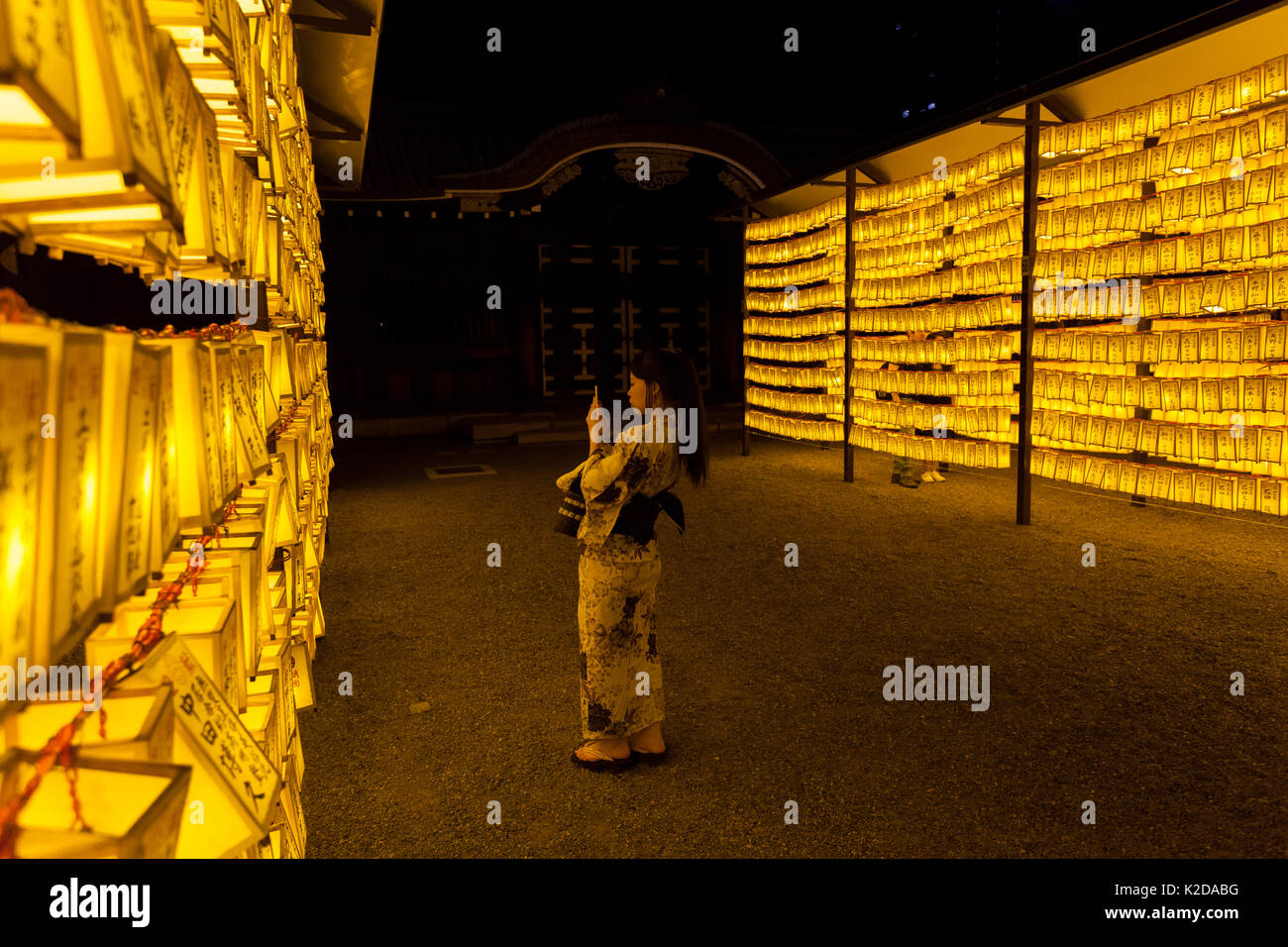 Una donna in un kimono scatta una foto di lanterne al Mitama matsuri nel controverso santuario Yasukuni a Kudanshita, Tokyo, Giappone. Foto Stock
