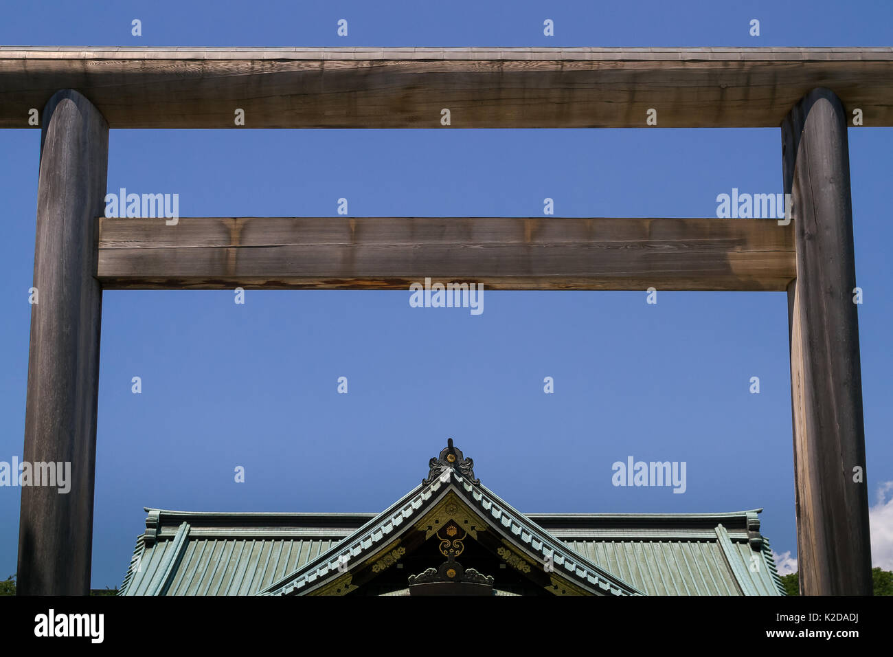 Una porta torii di fronte al tetto del Santuario Yasukuni a Kudanshita, Tokyo, Giappone. Foto Stock
