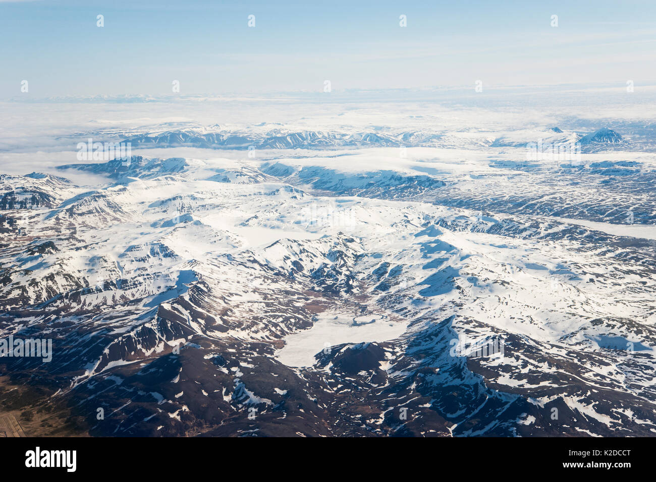 Vista aerea di montagne che mostra attraverso la copertura nuvolosa, Westfjords, Islanda. Aprile Foto Stock