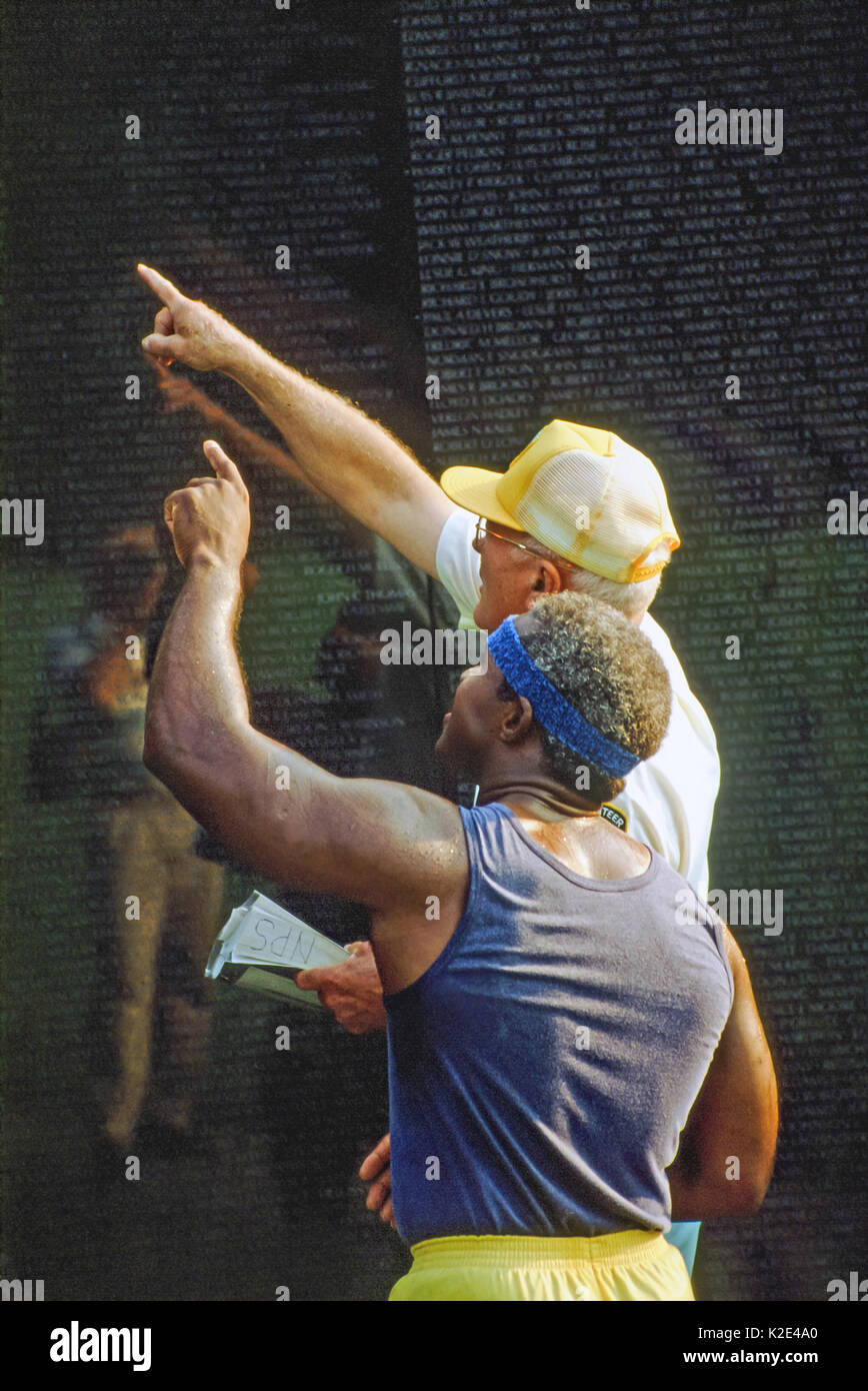Due uomini in cerca di un nome sul Vietnam Memorial Wall. Foto Stock