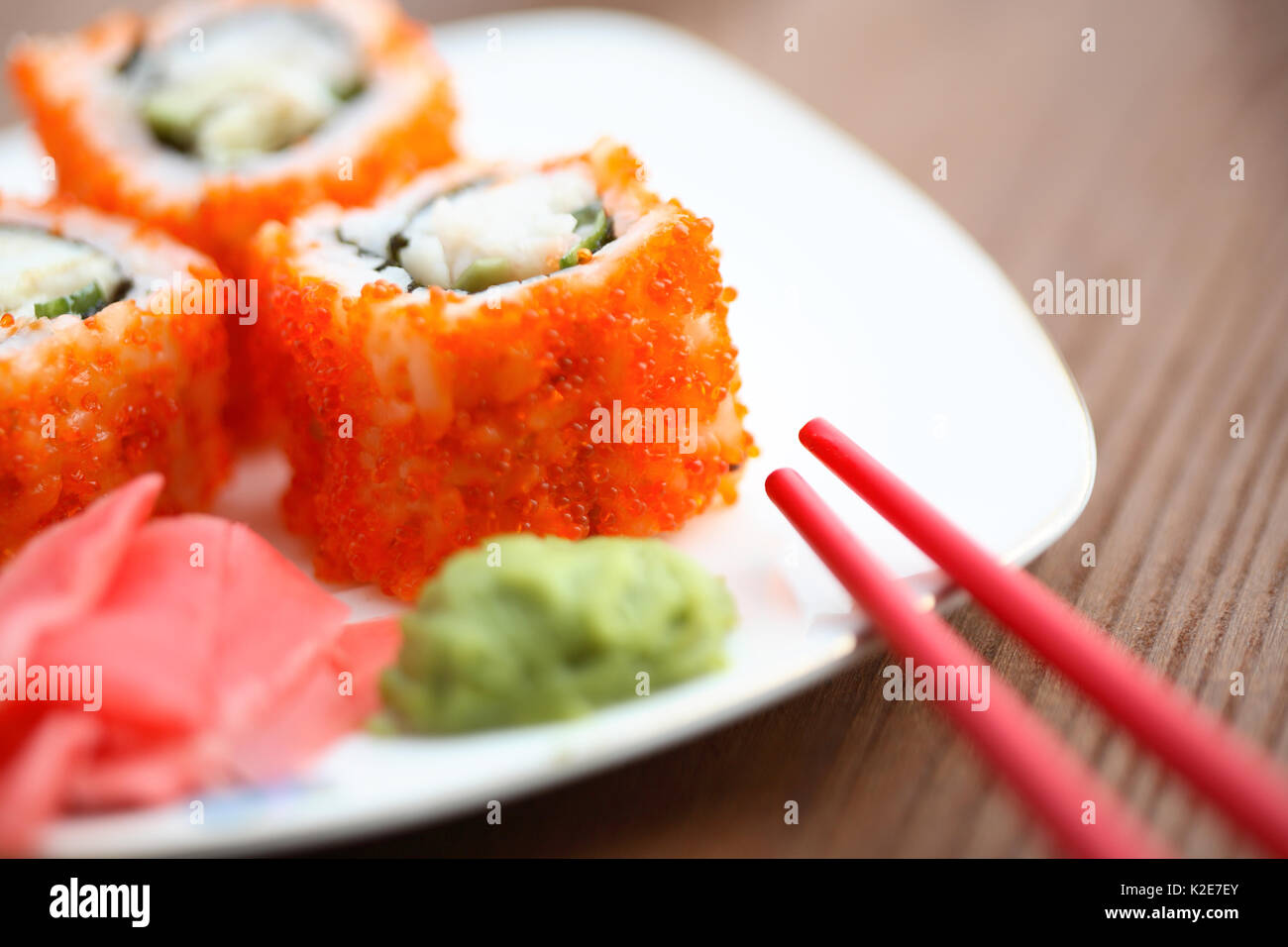 Tradizionale Giapponese sushi cotto e bastoncini su una superficie di legno. Extreme closeup Foto Stock