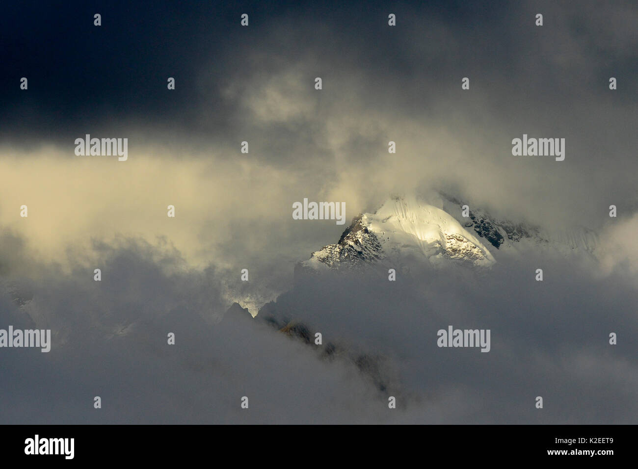 Nuvoloso sunrise nel Meili Neve Montagne, il punto più alto è il Kawa carpo (6740m). Yunnan, Cina, Ottobre 2016 Foto Stock