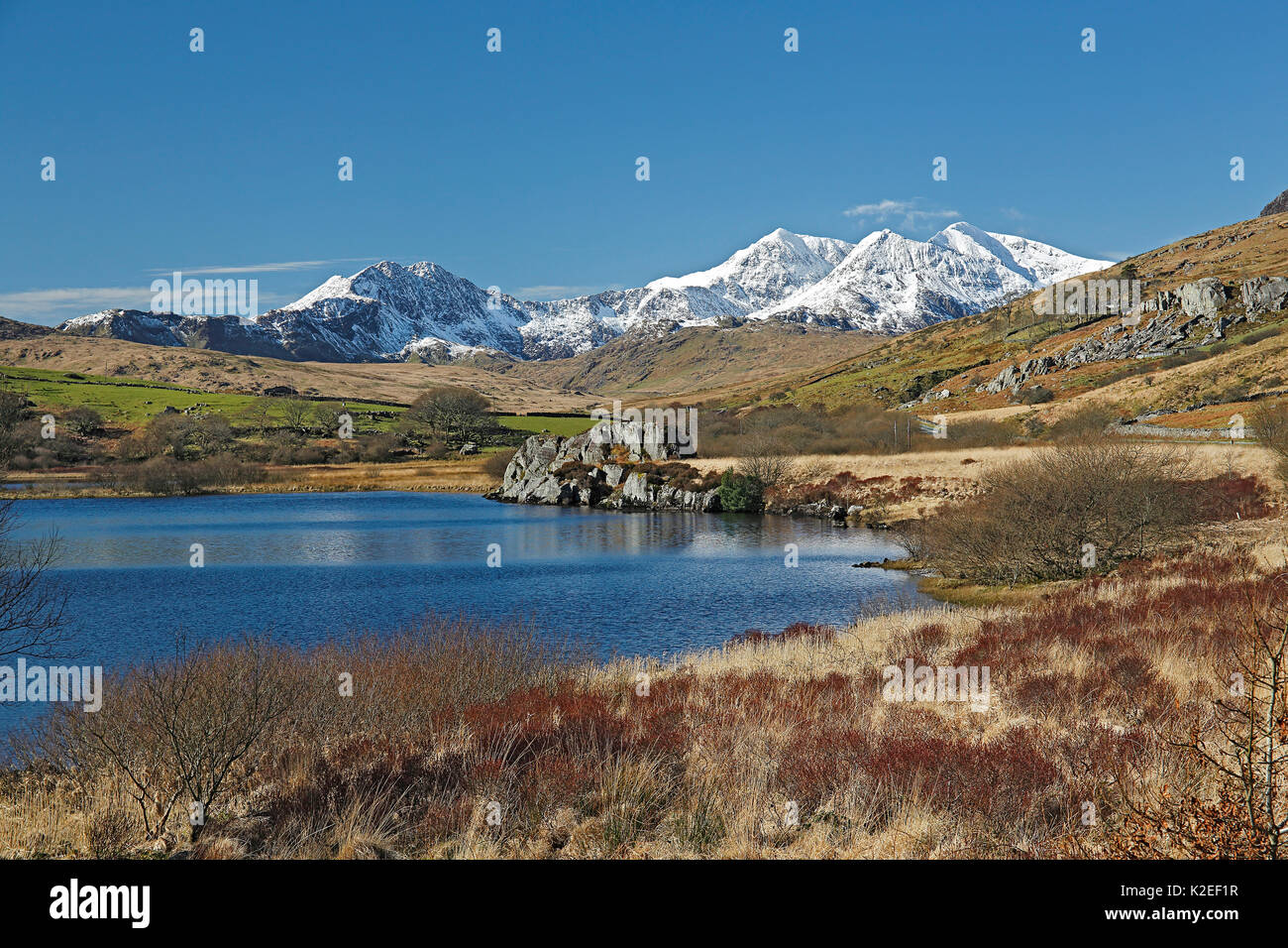Snowdon Mountain Range vista da ovest attraverso Llynnau Mymbyr Vicino a Capel Curig, Snowdonia National Park, il Galles del Nord, Regno Unito, Marzo. Foto Stock