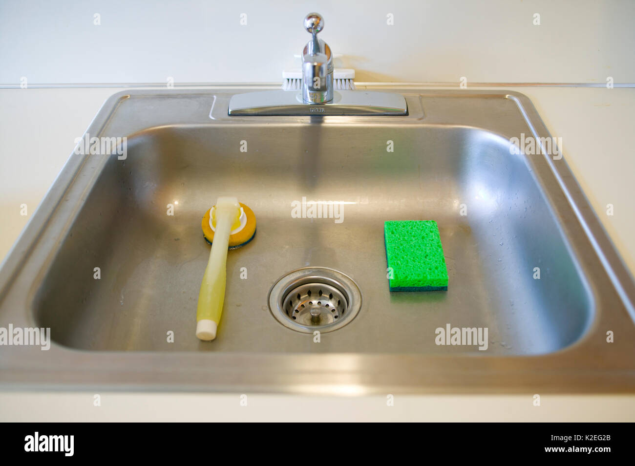 Ancora la vita di un lavello da cucina con una spugna e un piatto scrubber. Foto Stock