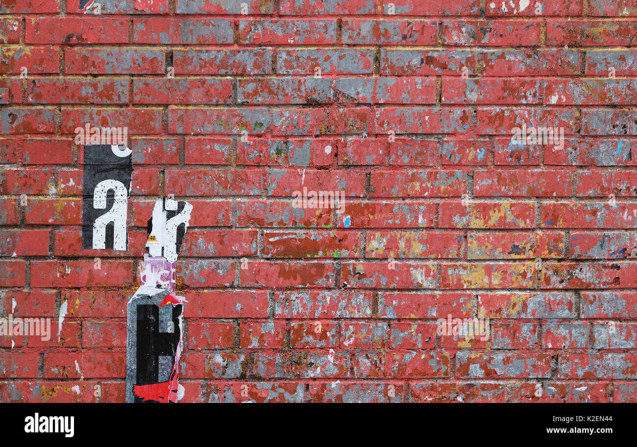 Urban Red Wall street texture con pezzi di poster incollato. Foto Stock