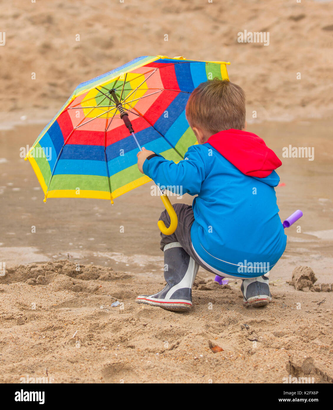 Il capretto con ombrello coloratissimo Foto Stock