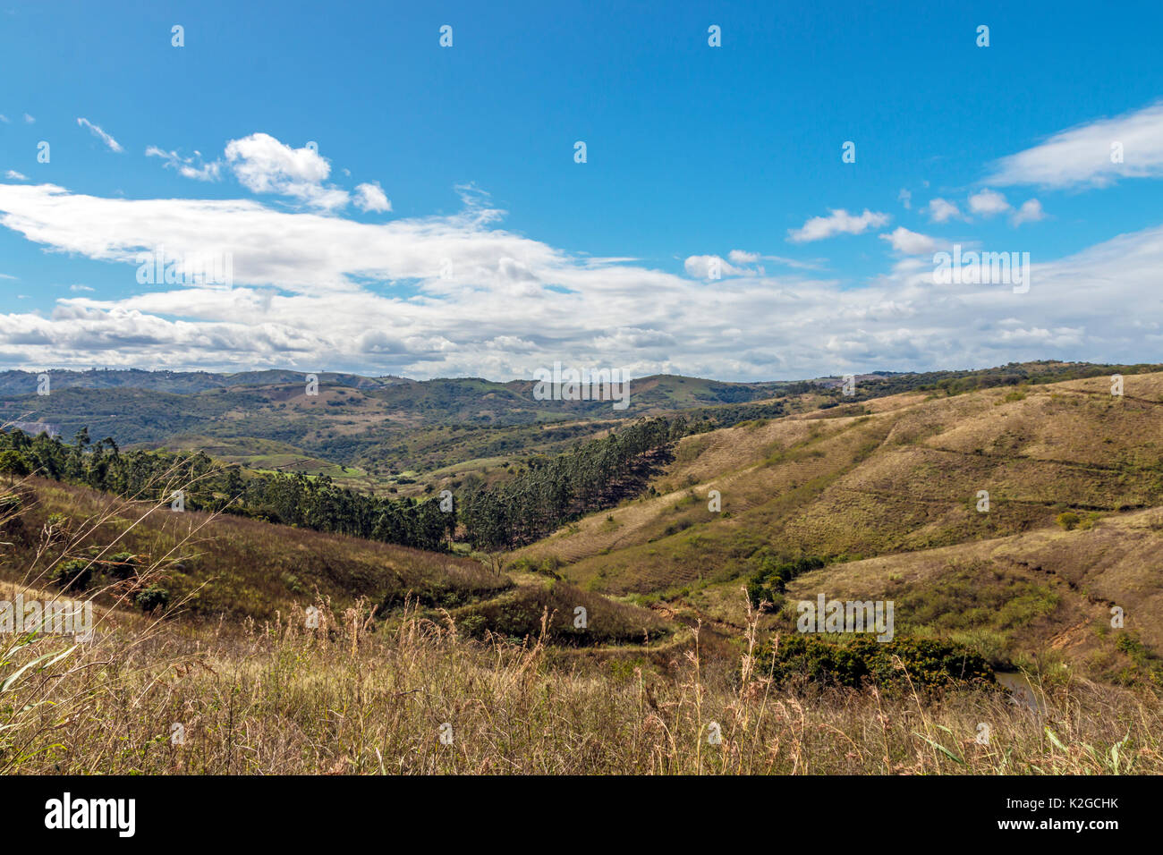 Asciugare rurale vegetazione invernale di colline e valli contro blu cielo nuvoloso deserto paesaggio in Sud Africa Foto Stock