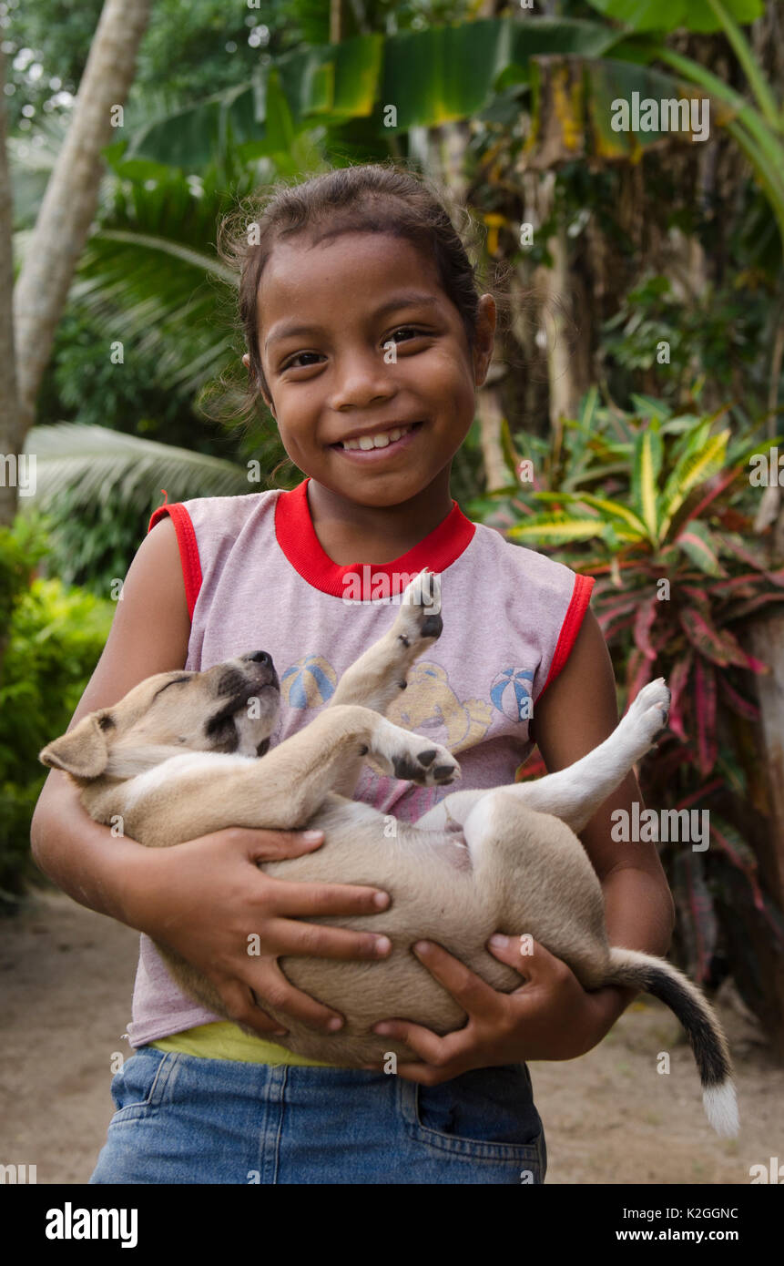 Ragazza locale azienda sleeping cucciolo, Kioa Isola, Figi, South Pacific, luglio 2014. Foto Stock