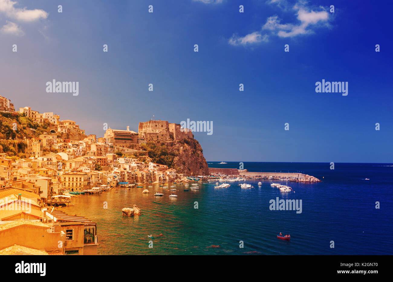 Scilla castello Ruffo e porto con barche da pesca in Calabria, Italia meridionale. Moderno e di colore arancione-blu applicato tonificante Foto Stock