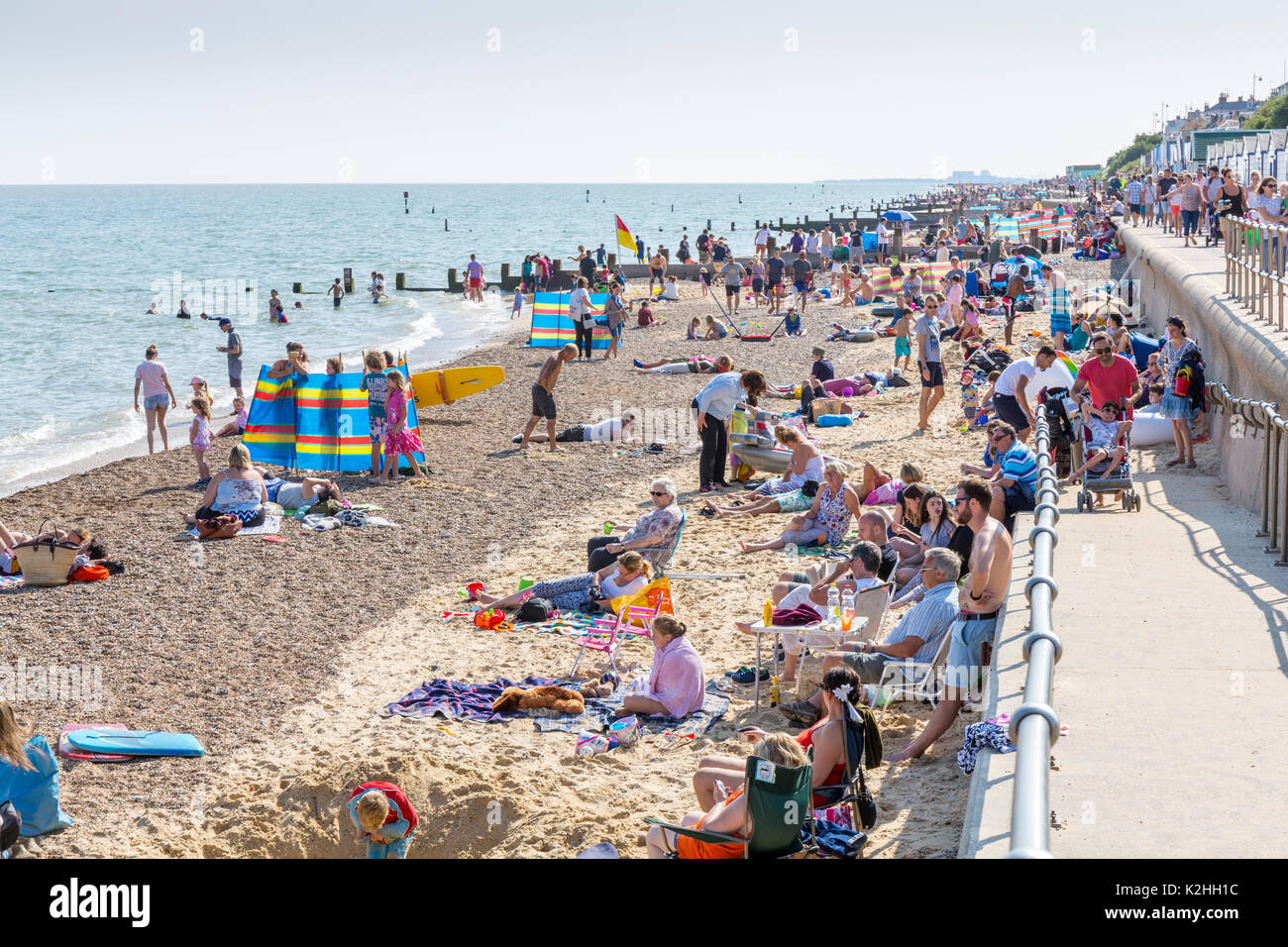 Alta Marea su una spiaggia affollata a Southwold, Suffolk, Inghilterra. Foto Stock