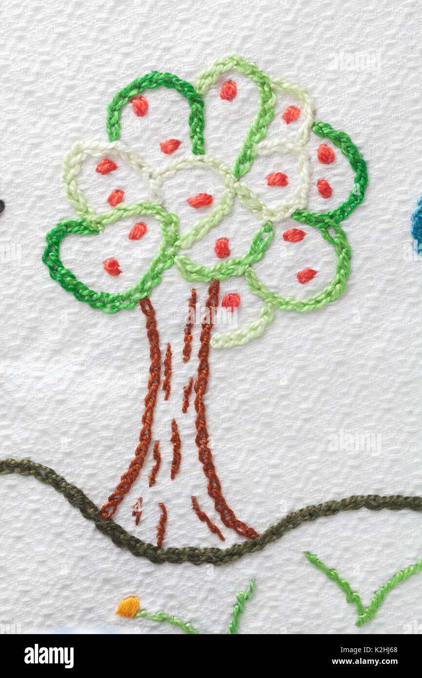 Ricamo con bimbo di motivi. Albero di mele con mele Foto Stock