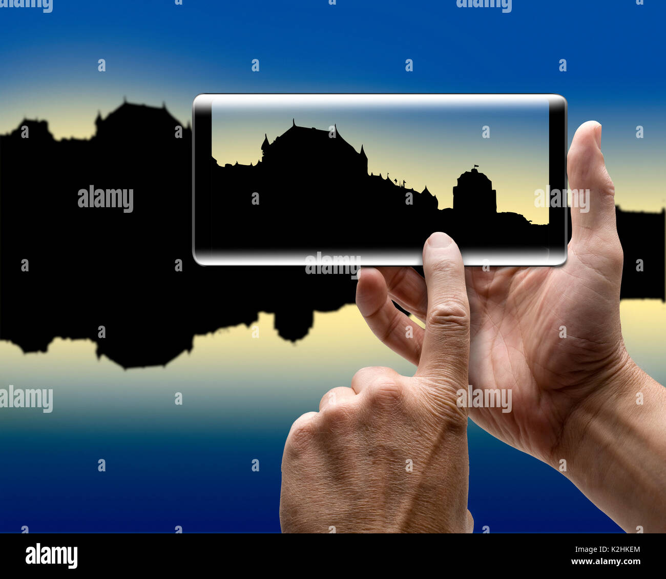 Due mani tenendo un mobile Smartphone e prendere un'immagine di una silhouette della città Foto Stock