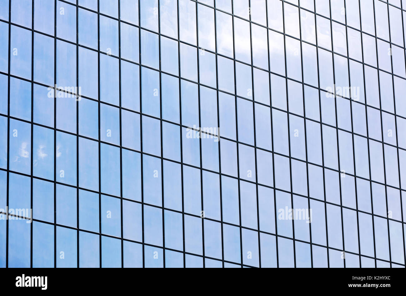 Moderno edificio facciata. parete in vetro che riflette il cielo blu. sfondo architettonico. Foto Stock