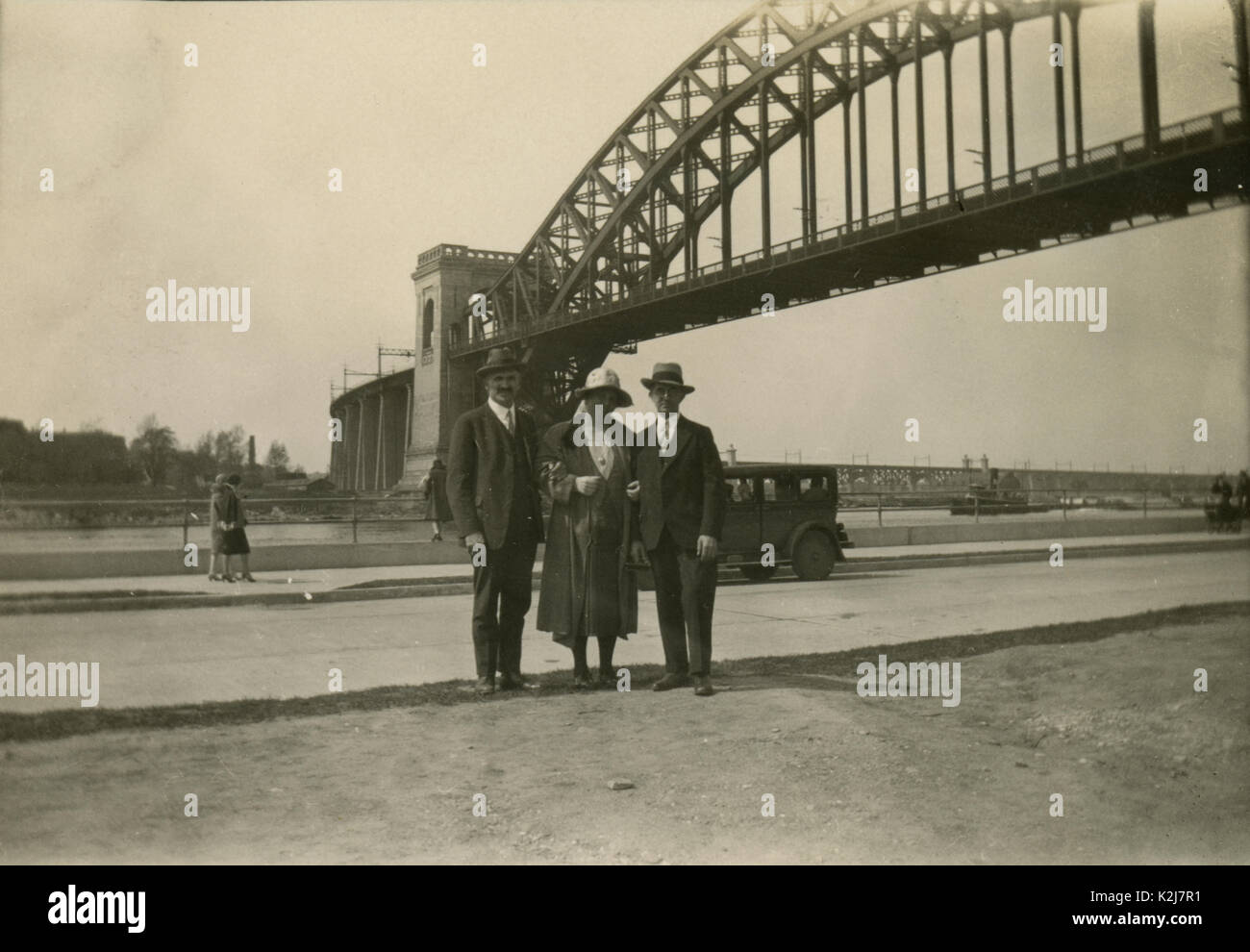 Antique c1920 fotografia, familiari pongono di fronte l'Hell Gate Bridge. L'Hell Gate Bridge è un 1,017-piede (310 m) in acciaio arco attraverso il ponte ferroviario in New York City. Il ponte attraversa il Hell Gate, lo stretto dell'East River, tra Astoria nel Queens e Randalls reparti e isole in Manhattan. Fonte: fotografia originale. Foto Stock