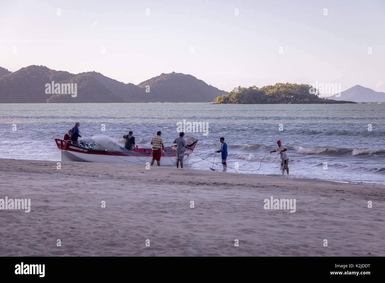 I pescatori in spiaggia con la Ilha das Cabras isola in background - Balneario Camboriu, Santa Catarina, Brasile Foto Stock