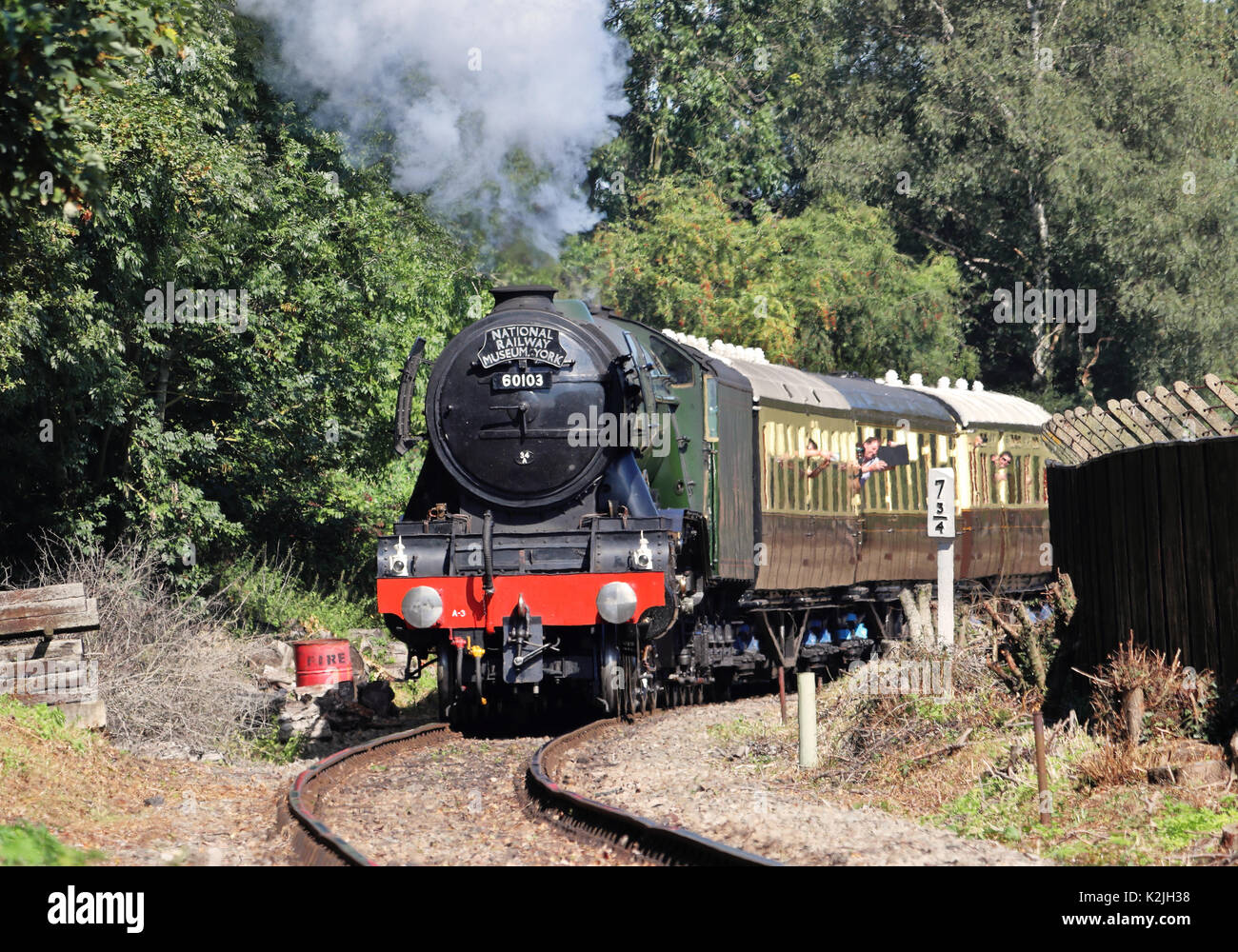 Flying Scotsman locomotiva a vapore e della cottura a vapore dei carrelli lungo RailwayTracks in Inghilterra Foto Stock