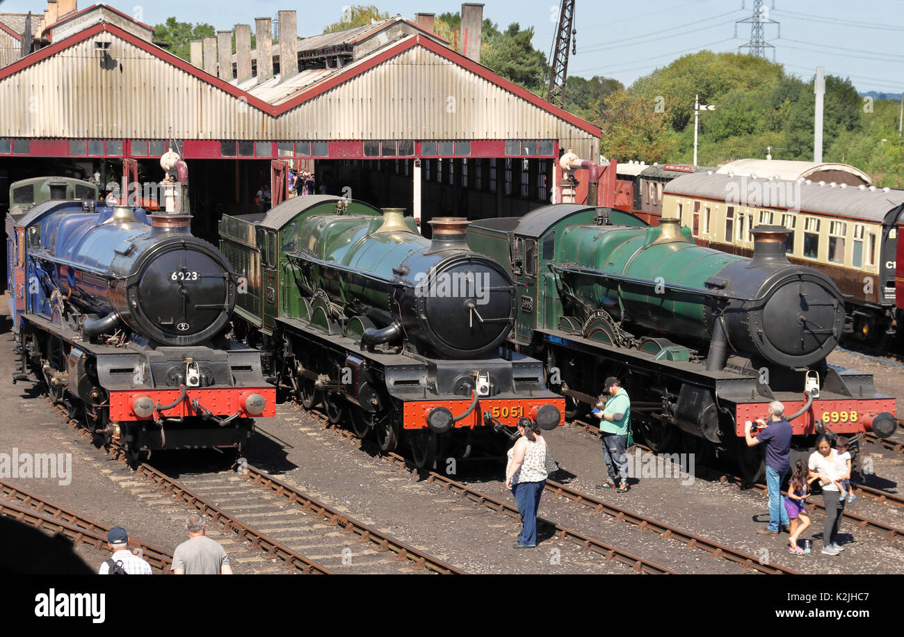 Fermo locomotiva a vapore e carrelli sulle vie al di fuori della loro capannoni a Didcot Railway Centre in Inghilterra Foto Stock