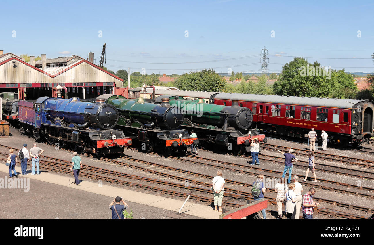 Fermo locomotiva a vapore e carrelli sulle vie al di fuori della loro capannoni a Didcot Railway Centre in Inghilterra Foto Stock