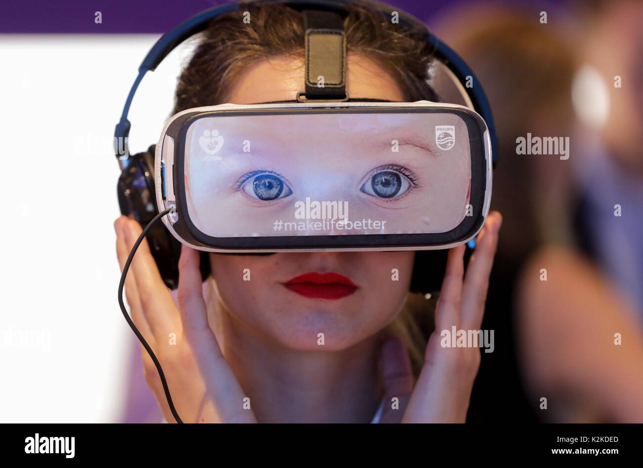 Berlino, Germania. 31 Agosto, 2017. Un membro del personale indossa 360 gradi di occhiali con una foto di due occhi presso lo stand di Philips durante la seconda giornata della stampa dell'esposizione industriale "Internationale Funkausstellung' (lit. "Radio International Exhibition") 2017 a Berlino, Germania, 31 agosto 2017. La fiera è aperta dal 1 al 6 settembre 2017. Foto: Kay Nietfeld/dpa/Alamy Live News Foto Stock
