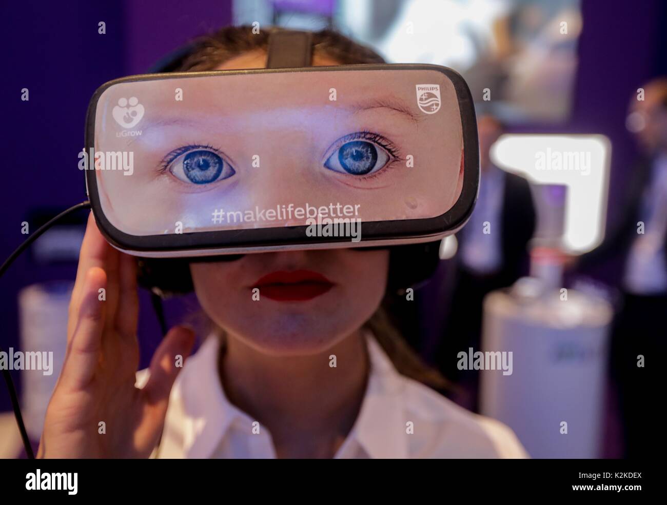Berlino, Germania. 31 Agosto, 2017. Un membro del personale indossa 360 gradi di occhiali con una foto di due occhi presso lo stand di Philips durante la seconda giornata della stampa dell'esposizione industriale "Internationale Funkausstellung' (lit. "Radio International Exhibition") 2017 a Berlino, Germania, 31 agosto 2017. La fiera è aperta dal 1 al 6 settembre 2017. Foto: Kay Nietfeld/dpa/Alamy Live News Foto Stock