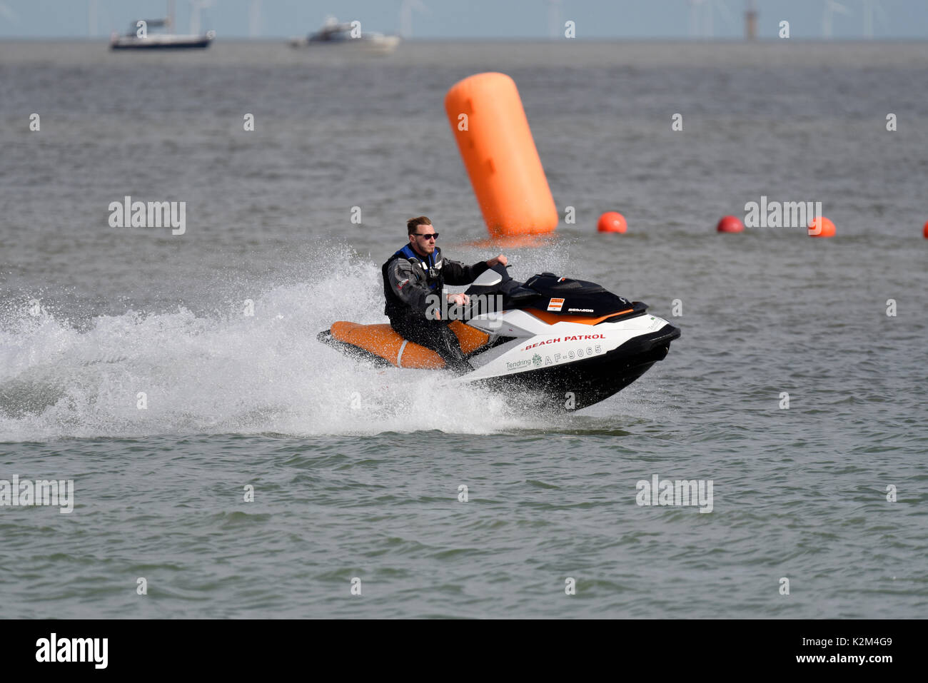 Moto d'acqua di pattuglia sulla spiaggia del Consiglio del distretto di Tendring al Clacton Airshow. Clacton on Sea, Essex. Visualizza boe marker lineari oltre Foto Stock