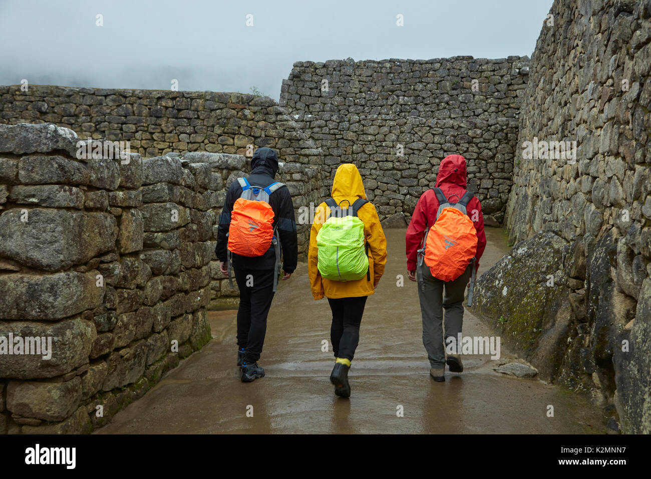 I turisti in pioggia a Machu Picchu xv secolo rovine Inca (sito Patrimonio Mondiale), la Valle Sacra, Perù, Sud America (MR) Foto Stock