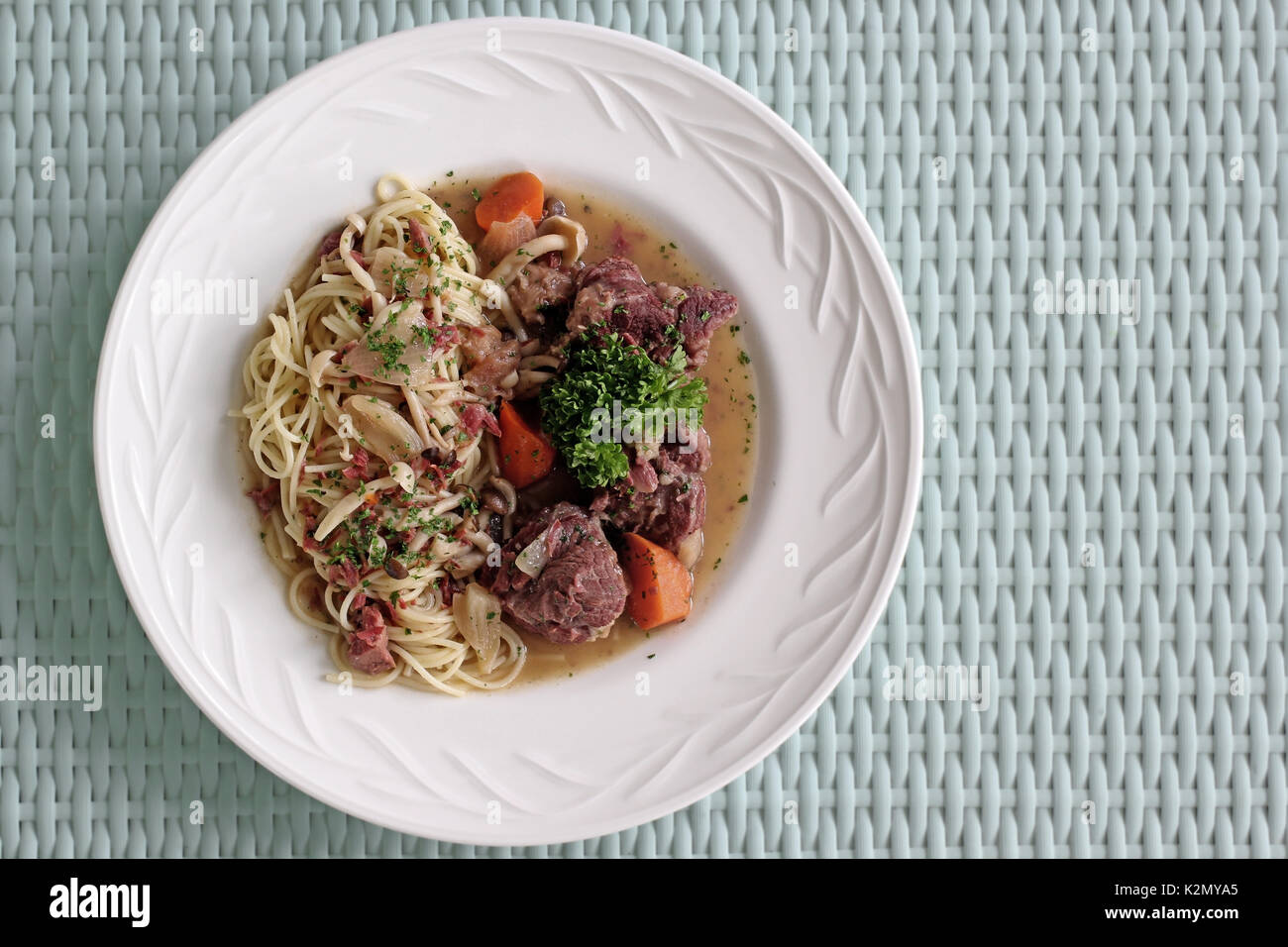 Deliziosi piatti della cucina italiana spaghetti con osso di maiale sul tavolo di legno Foto Stock