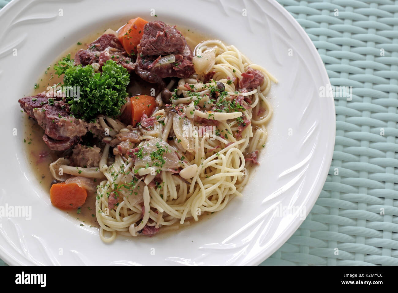 Deliziosi piatti della cucina italiana spaghetti con osso di maiale sul tavolo di legno Foto Stock