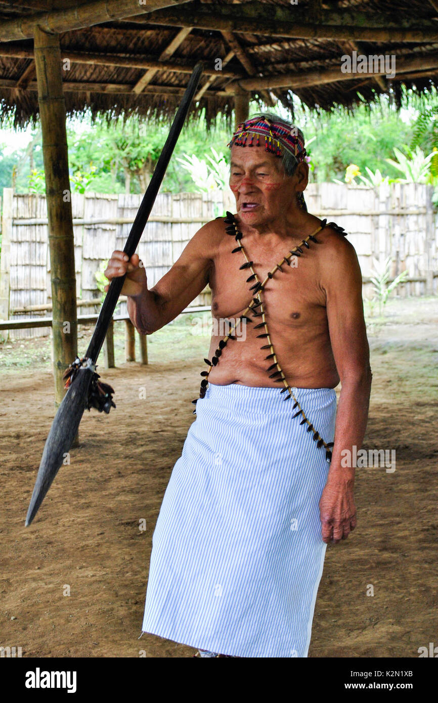 Un Shuar uomo vecchio messaggio di saluto. Egli indossa accesories fatta di semi. Comunità Shuar. Bucay. Proviince di Guayas. Ecuador Foto Stock