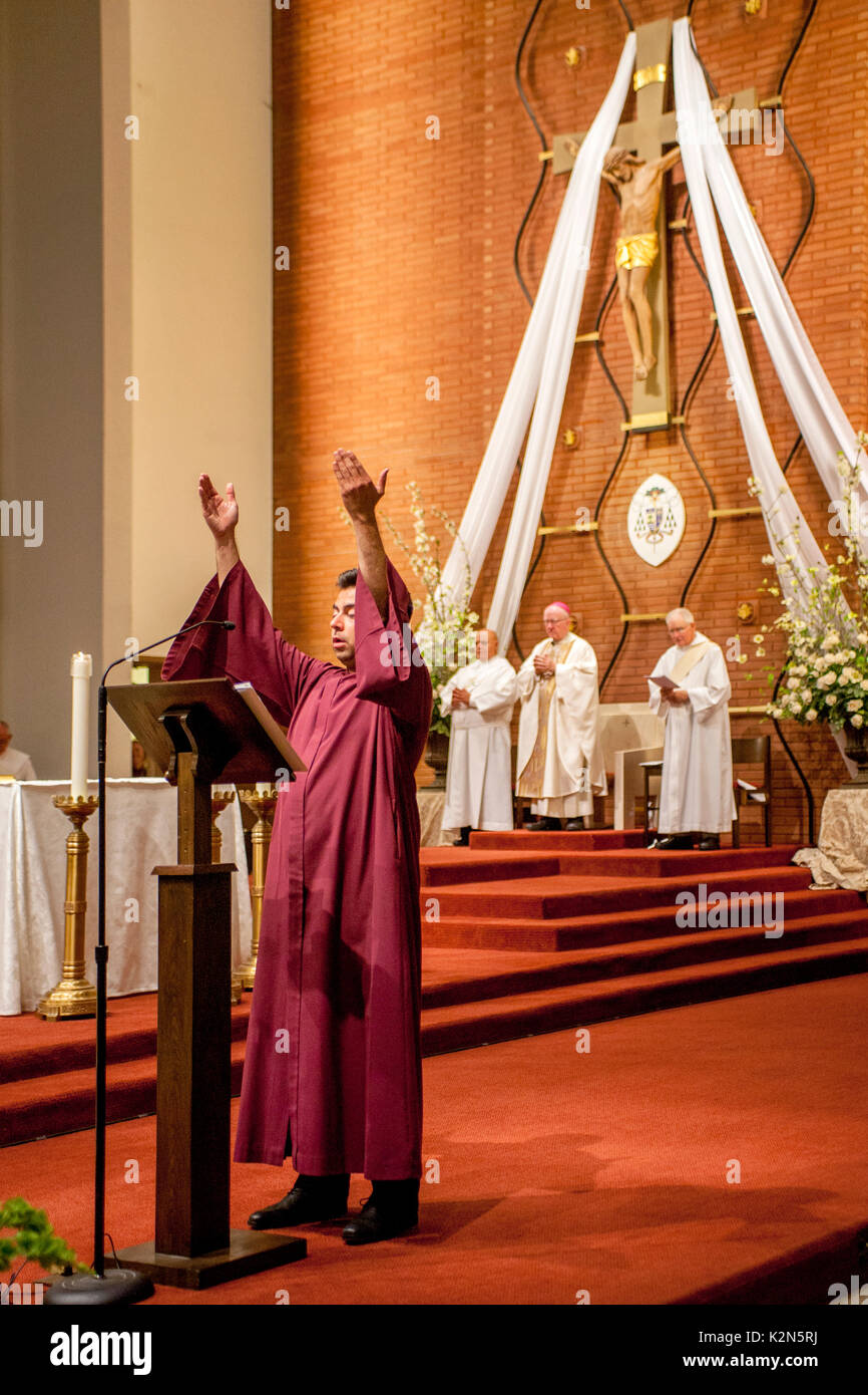 Un cantore conduce la congregazione nella preghiera durante una massa condotta da un vescovo cattolico in una cattedrale in arancione, CA. Foto Stock