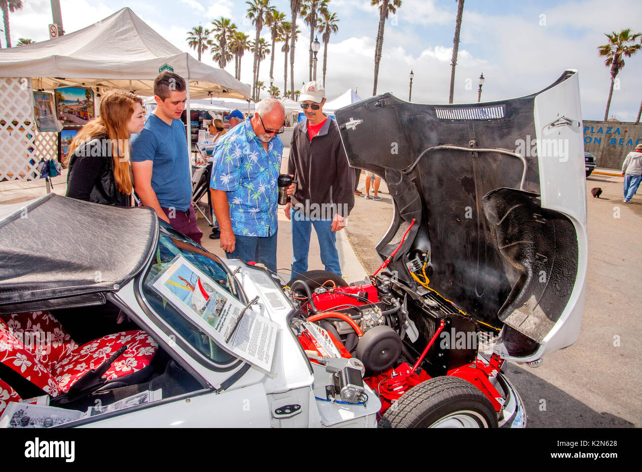 Il proprietario di un classico 1965 Triumph Spitfire Mark 2 British sports car mostra la sua ripristinato il motore a un auto show nel centro cittadino di Huntington Beach, CA. Foto Stock
