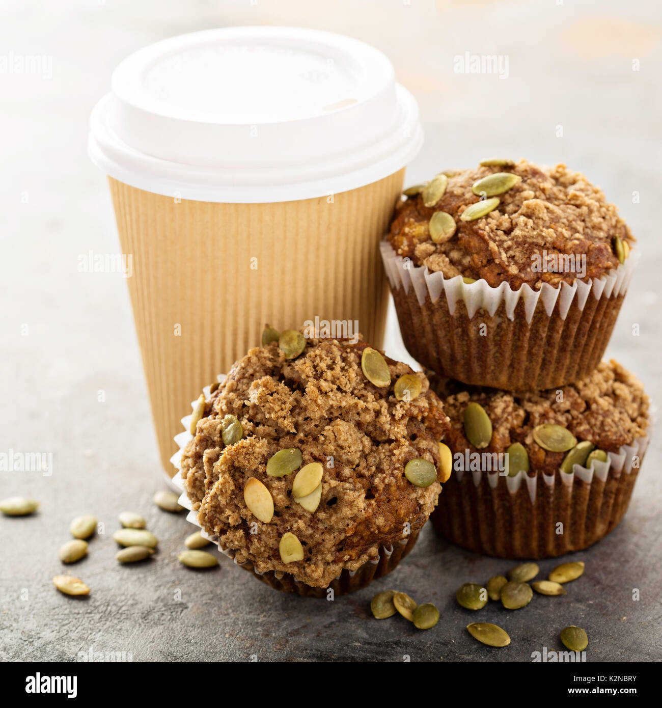 Sana muffin di zucca con l'autunno di spezie e semi di zucca con una tazza di caffè per andare Foto Stock