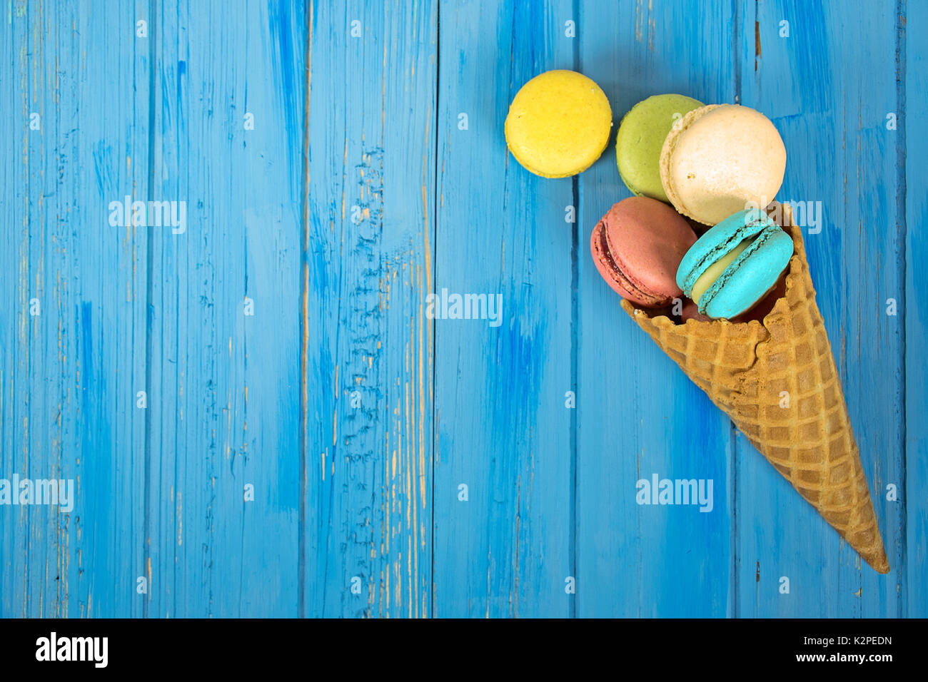 Amaretto francese i cookie nel cono di cialda nel blu dipinto di legno Foto Stock