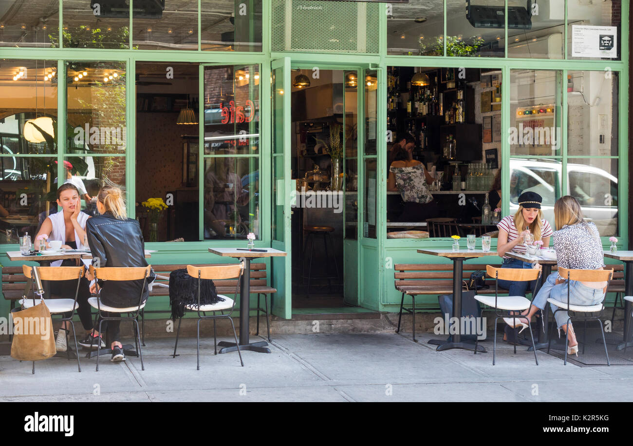 Quattro giovani attraenti donne aventi un pranzo alfresco presso un bistro Nolita n Lower Manhattan Foto Stock