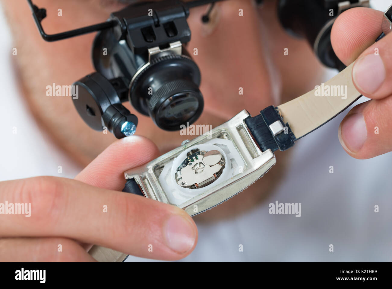 Close-up di giovane uomo cerca orologio da polso con lente di ingrandimento Foto Stock