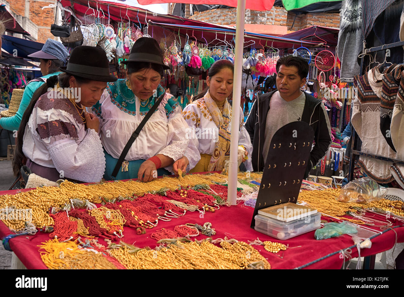 Aprile 29, 2017 Otavalo, Ecuador: indigeni donne quechua davanti a un cavalletto di gioielli in il mercato del sabato Foto Stock