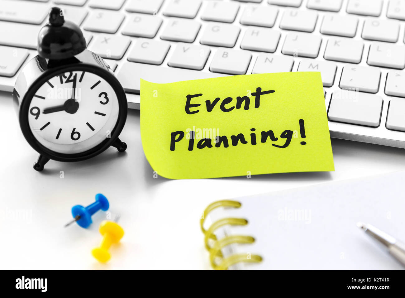 Pianificazione di eventi parola su notepad con orologio bianco sulla scrivania del computer Foto Stock