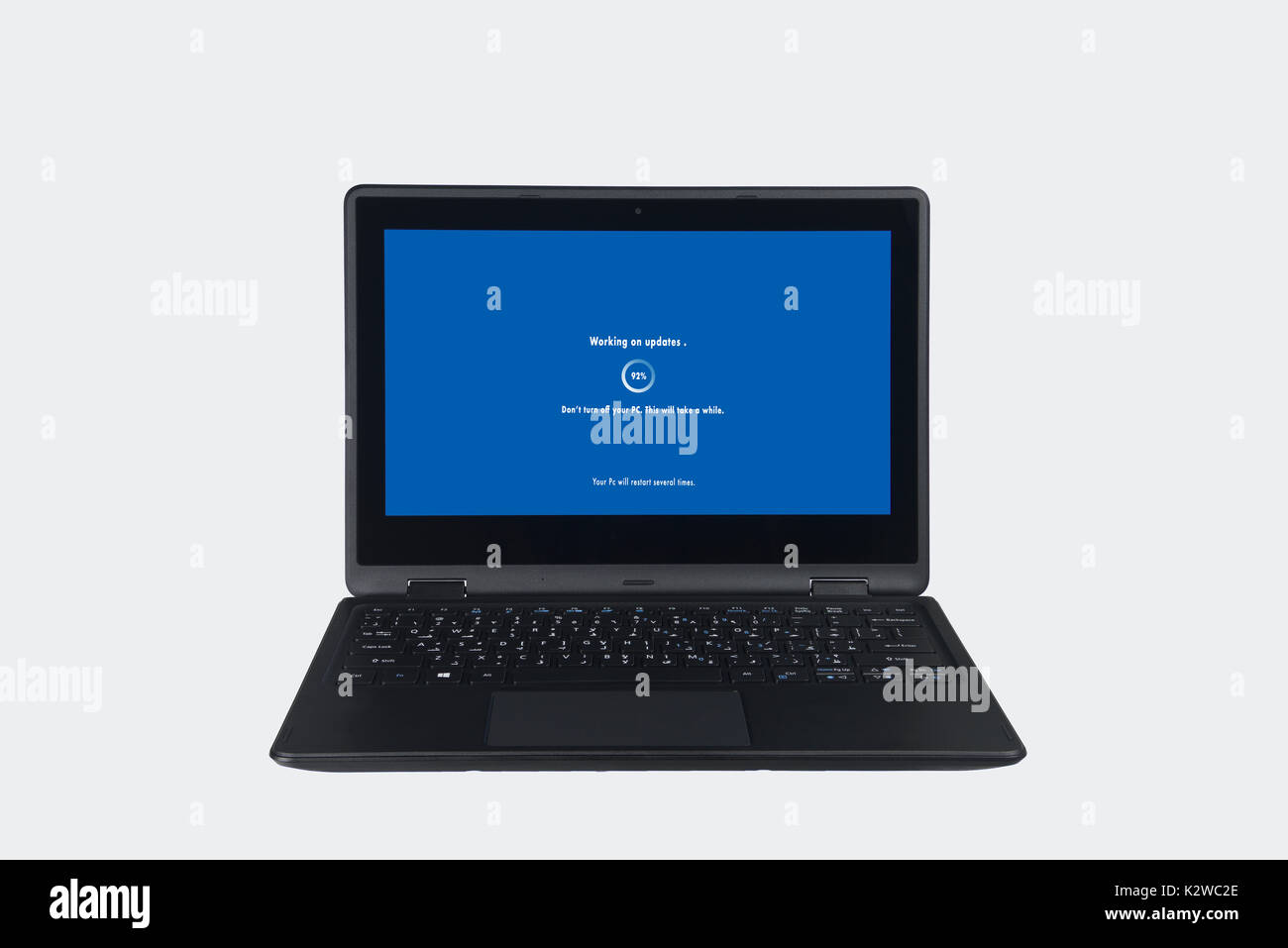 Notebook su sfondo bianco con un aggiornamento software in corso, PC aggiornato alla versione più recente, dispositivo moderno in fase di aggiornamento Foto Stock