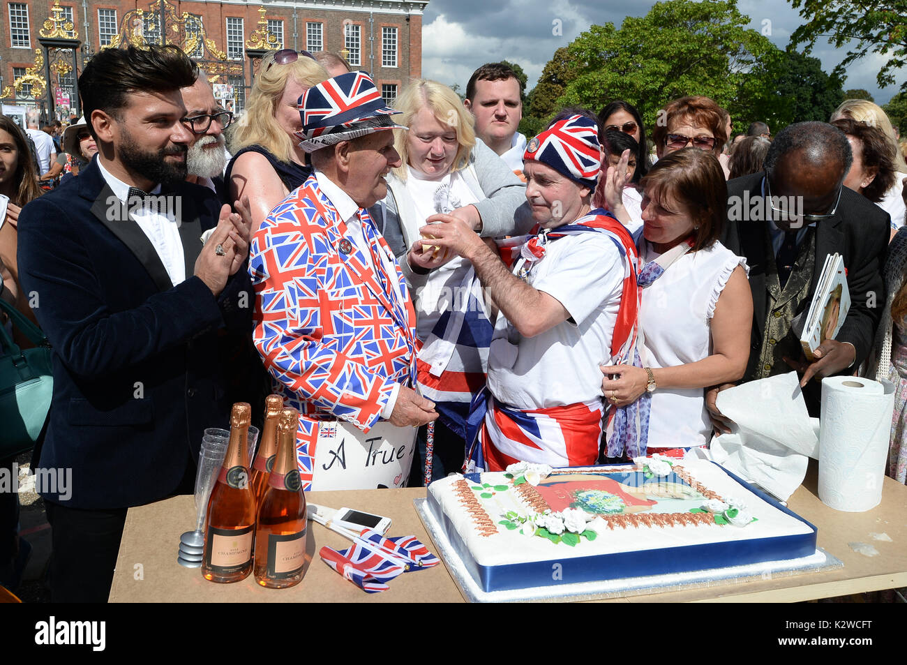Royal ventole Terry Hut e John Loughrey tagliare una fetta di torta in occasione del ventesimo anniversario della morte di Lady Diana, principessa di Galles, fuori Kensington Palace a Londra. Foto Stock