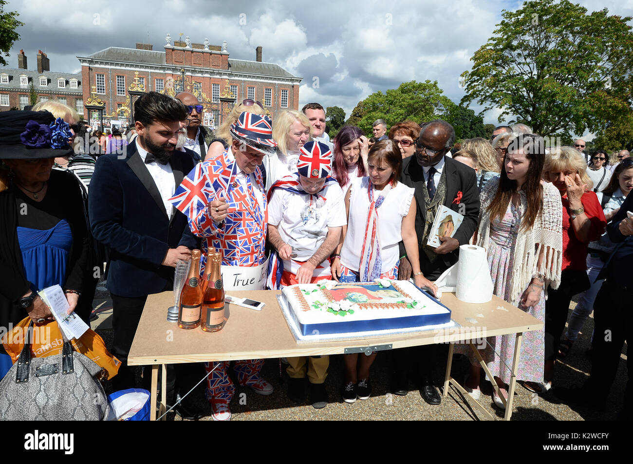 Royal ventole Terry Hut e John Loughrey tagliare una fetta di torta in occasione del ventesimo anniversario della morte di Lady Diana, principessa di Galles, fuori Kensington Palace a Londra. Foto Stock