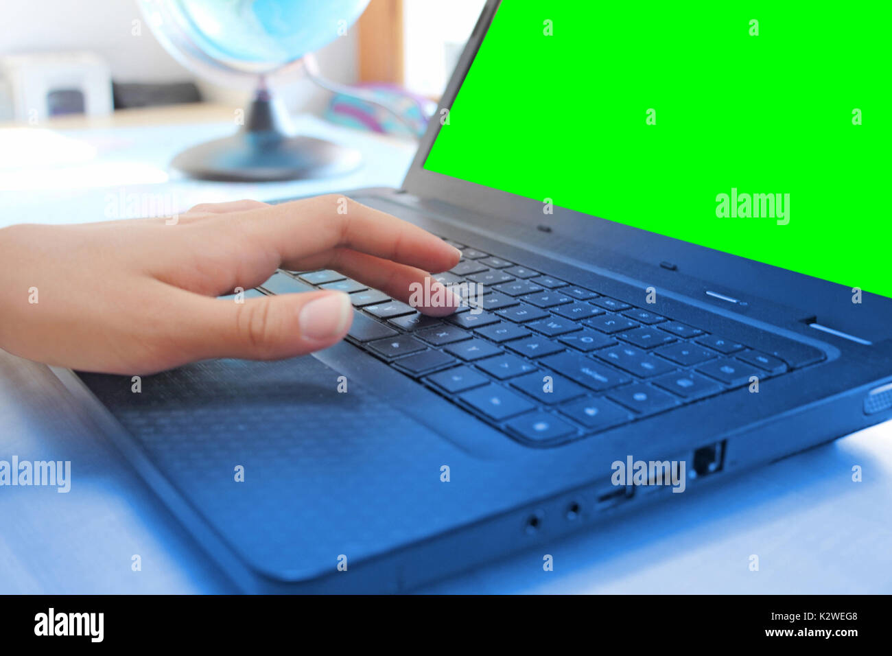 Le donne le mani lavorando sul computer portatile in ufficio su schermo verde Foto Stock