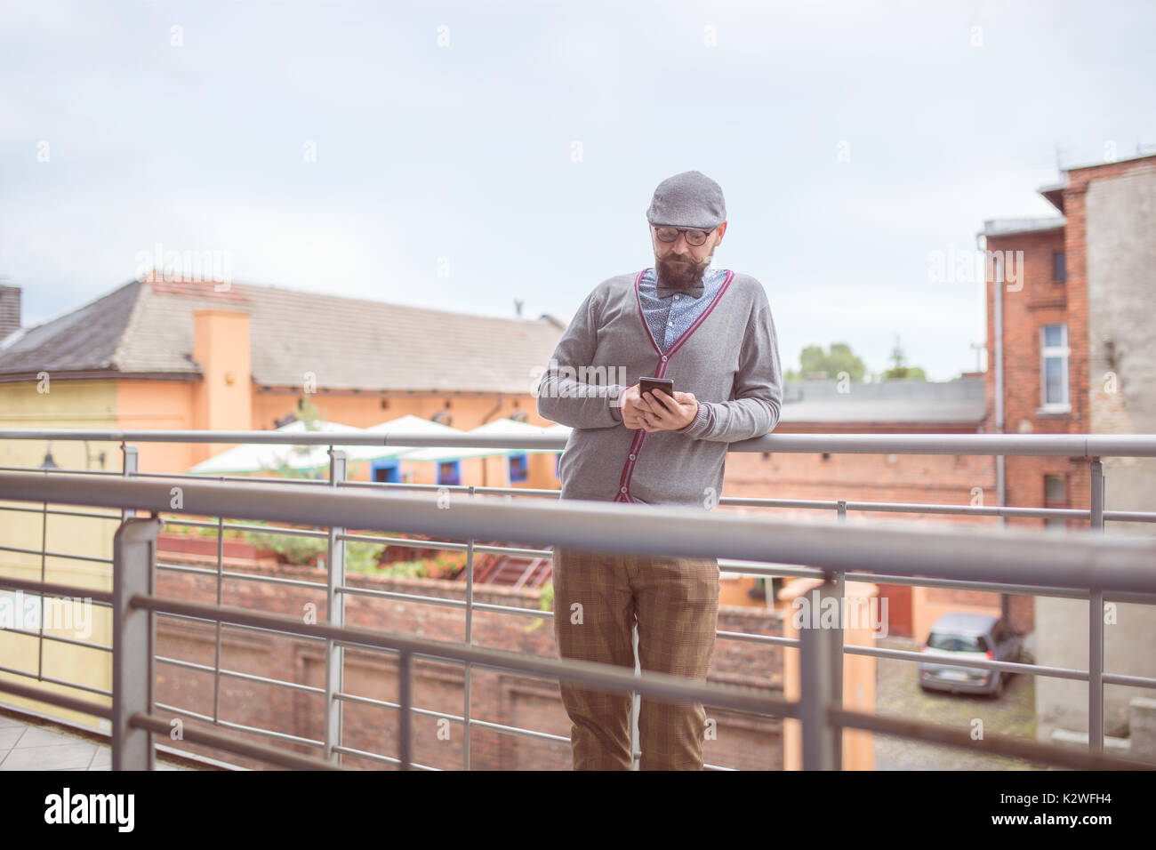 Moda uomo in piedi alla terrazza e navigare in rete Foto Stock