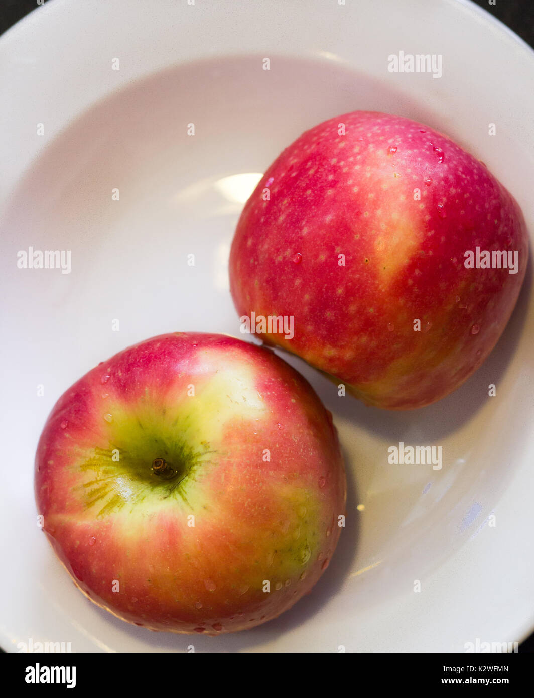 Mele rosa in una piastra bianca Foto Stock